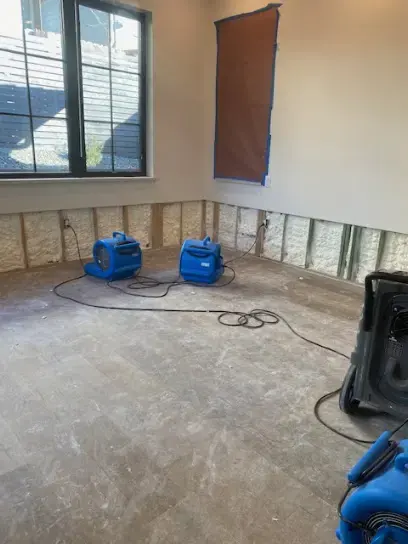 Air movers drying a room after the lower drywall was cut out