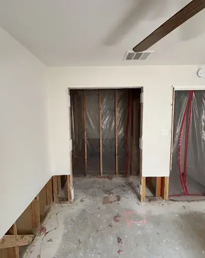 Drywall cut above the floor and containment set up in a room during drying