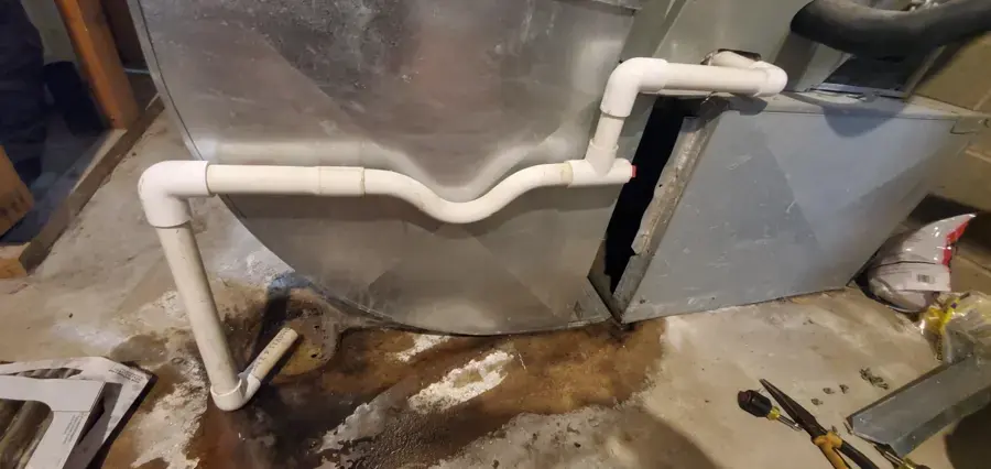 Water pooled under an air handler from a clogged condensate drain