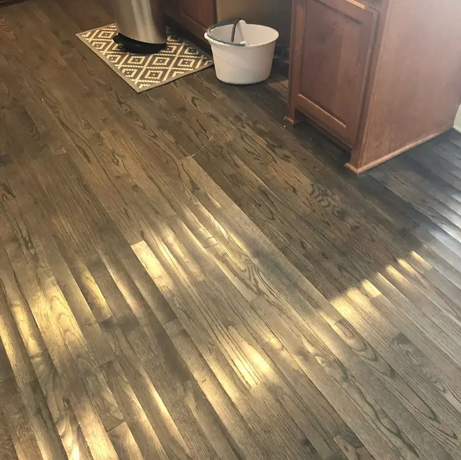 Cupped wood floor boards after a water leak in a kitchen